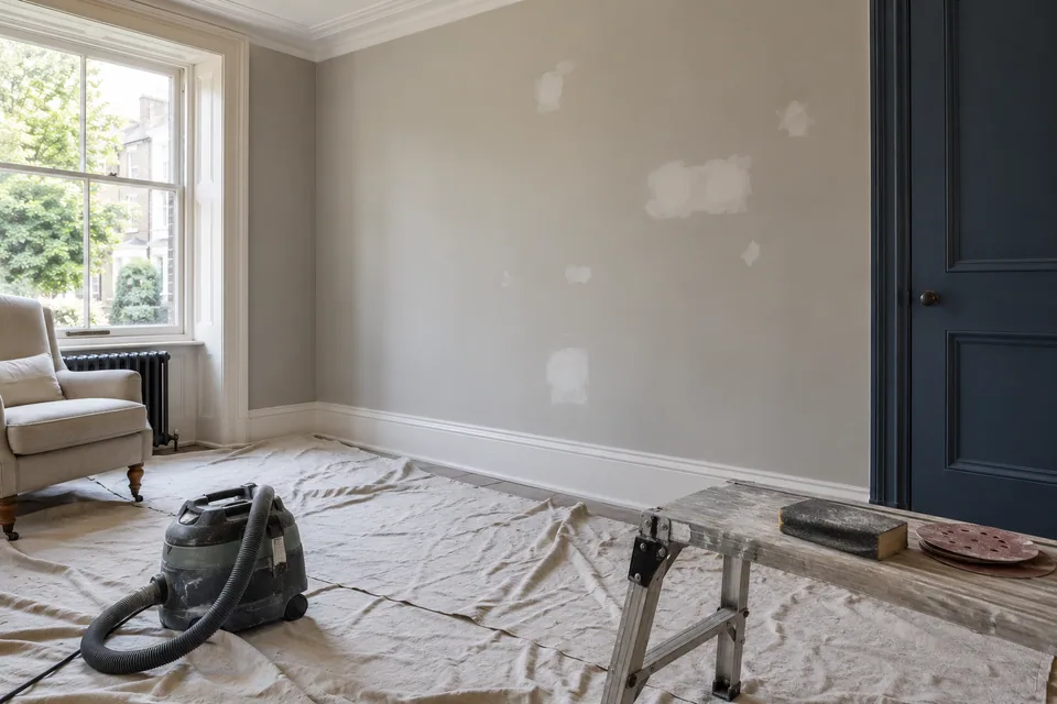 Walls prepared for decorating with protected floor and shallow filled areas